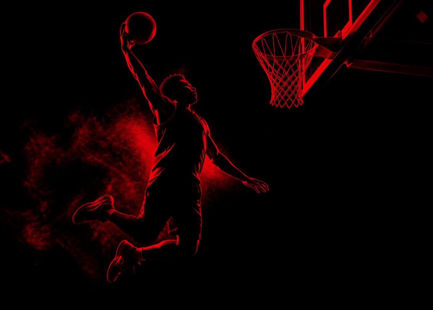 Georgia Power player finishing a dunk in front of a crimson-lit crowd